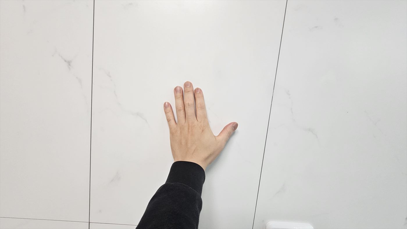 복원을 마친 아트월 타일에 손을 대어 본 모습, 메꾼 자리가 보이지 않는다